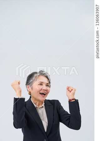 一位身著西裝的老年女性擺姿勢以示支持 一位身著西裝的老年女性擺姿勢以示支持 136063907