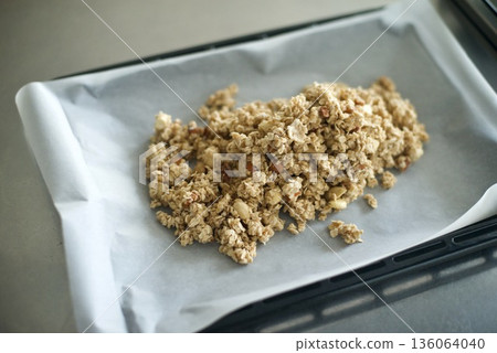 將格蘭諾拉麥片鋪在盤子上,放入烤箱烘烤。 將格蘭諾拉麥片鋪在盤子上,放入烤箱烘烤。 136064040