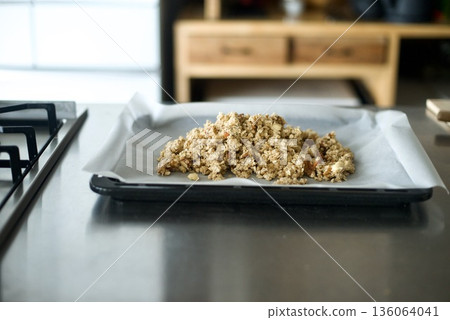 將格蘭諾拉麥片鋪在盤子上,放入烤箱烘烤。 將格蘭諾拉麥片鋪在盤子上,放入烤箱烘烤。 136064041