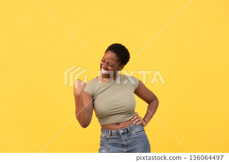 Excited young woman celebrating success against Excited young woman celebrating success against 136064497