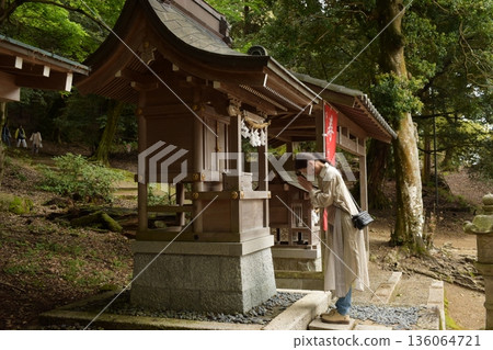 Senior woman praying at a shrine 136064721