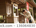 Senior woman praying at a shrine 136064830