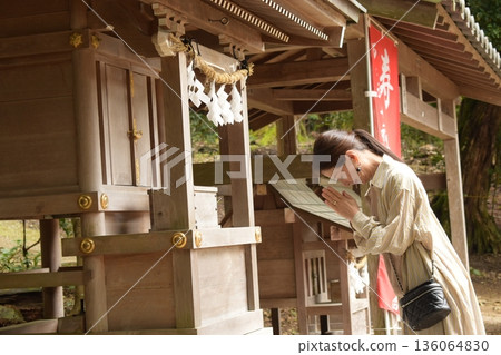 Senior woman praying at a shrine Senior woman praying at a shrine 136064830