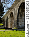 Historic stone aqueduct with arches in urban park sunny day blue sky ancient masonry architecture Portugal. High quality photo 136065108