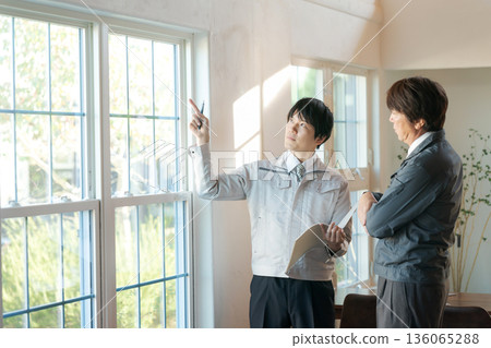 一個身穿工作服的男人正在窗前開會。 136065288