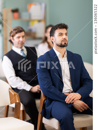 Lecture or meeting participants listen to speaker 136065322