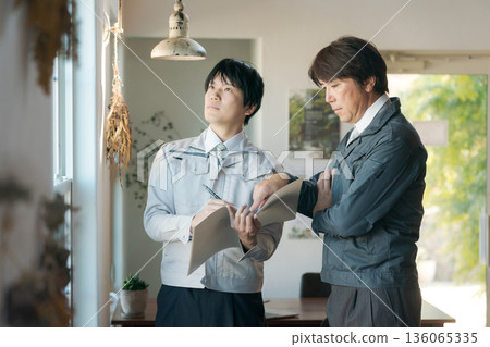 一個身穿工作服的男人正在窗前開會。 136065335