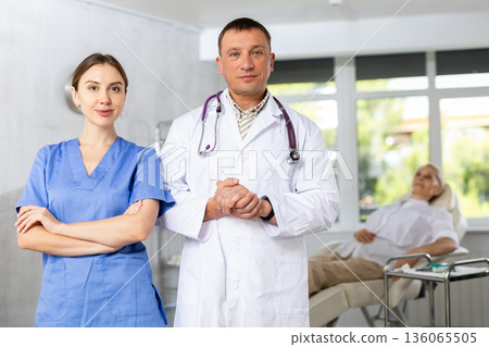 Two confident experienced doctor colleagues standing in medical office Two confident experienced doctor colleagues standing in medical office 136065505