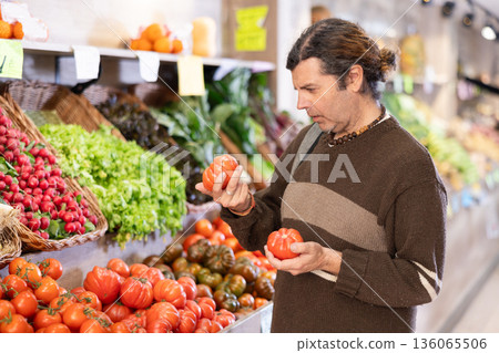 European chooses tomatoes at the counter European chooses tomatoes at the counter 136065506