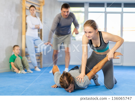 Teen girl in gym perform basic elements of krav maga self-defense system. Teen girl in gym perform basic elements of krav maga self-defense system. 136065747