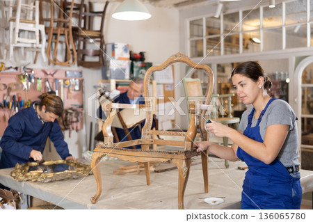 woman restorer spackling antique chair surface getting piece of furniture ready for further coloring 136065780