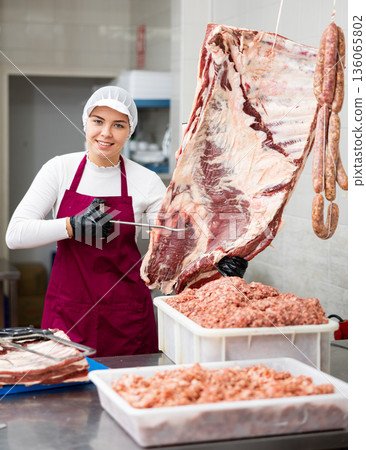 Young woman butcher holding beef ribs Young woman butcher holding beef ribs 136065802