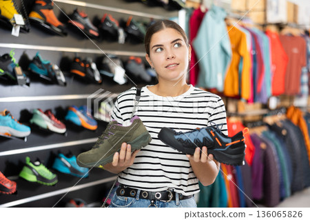 Girl examine compare item of autumn comfortable tracking shoes 136065826