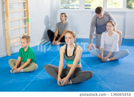 Big family before training martial arts performs stretching butterfly 136065858