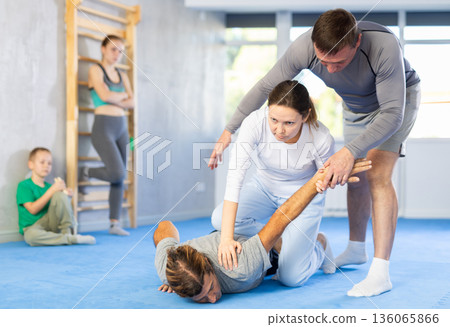 Woman student, with help of male teacher, completes neutralization of opponent 136065866