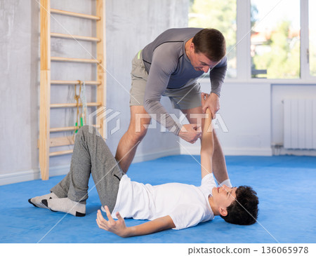Man and boy teenager training self-defense techniques Man and boy teenager training self-defense techniques 136065978