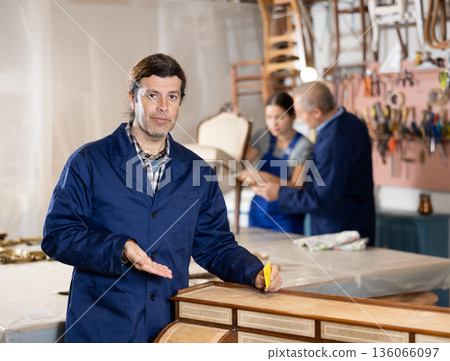 Male carpenter working on making vintage commode in workshop 136066097