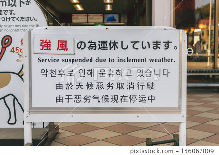 Signs announcing service suspension due to strong winds. Multilingual warning signs. Service suspension. Signs announcing service suspension due to strong winds. Multilingual warning signs. Service suspension. 136067009