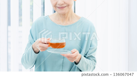 一位老婦人正在喝熱飲 136067047