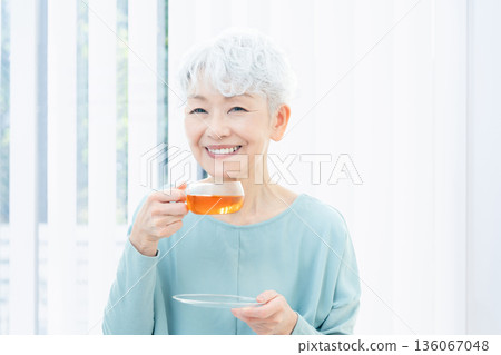 一位老婦人正在喝熱飲 136067048