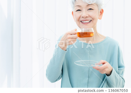 一位老婦人正在喝熱飲 136067050
