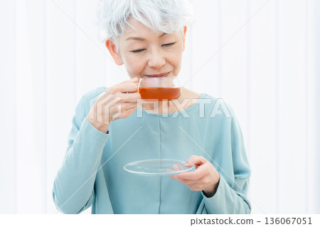 一位老婦人正在喝熱飲 136067051