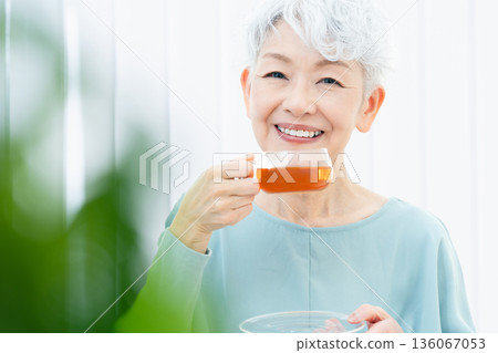 一位老婦人正在喝熱飲 136067053