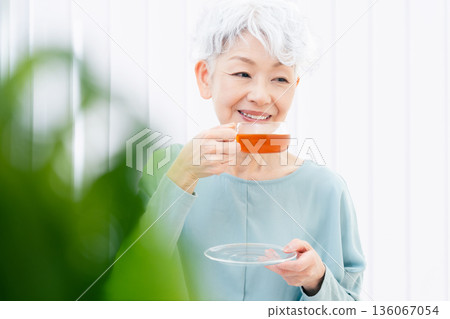 一位老婦人正在喝熱飲 136067054