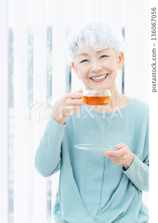 一位老婦人正在喝熱飲 136067056