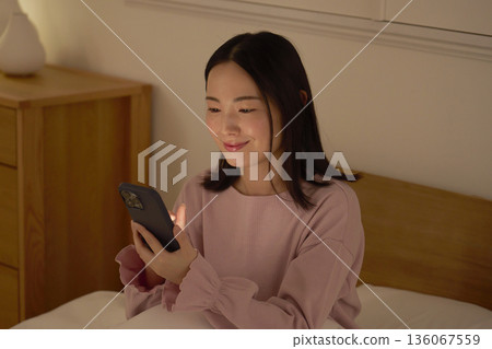 一個在床上使用智能手機的女人 136067559