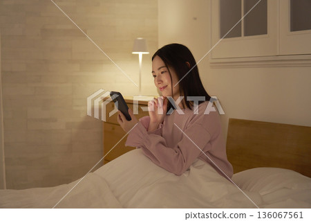 一個在床上使用智能手機的女人 136067561