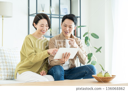 一對中年夫婦在客廳使用平板電腦 136068862
