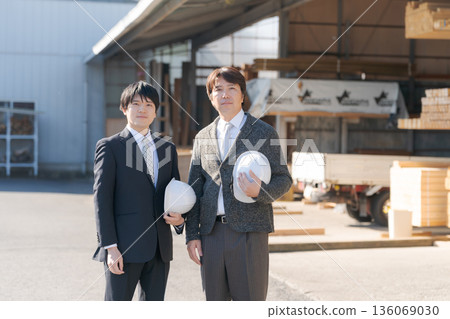 A man in a suit standing in a lumberyard 136069030
