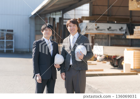 A man in a suit standing in a lumberyard 136069031