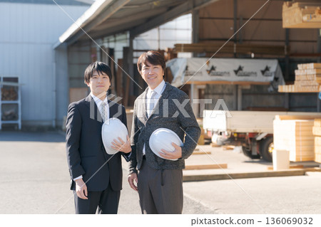 A man in a suit standing in a lumberyard 136069032