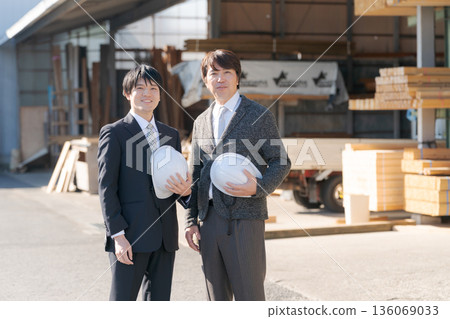 A man in a suit standing in a lumberyard A man in a suit standing in a lumberyard 136069033