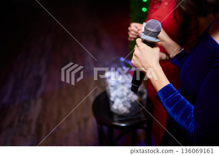 Intimate performance scene, Candid moment of performer amidst lively nightlife background, Confident singer showcased in dim neon lighting with friends enjoying performance 136069161