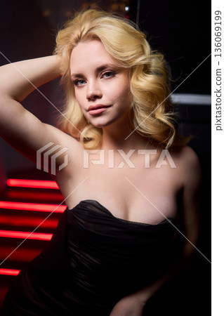 Elegant night scene, Sophisticated female model exuding confidence during evening event, Fashion forward woman highlighted by striking red lighting at glamorous social gathering Elegant night scene, Sophisticated female model exuding confidence during evening event, Fashion forward woman highlighted by striking red lighting at glamorous social gathering 136069199