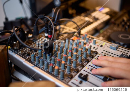 Engineer finetuning sound signals using patch cables, Focused technician adjusting levels on electronic patch cable setup with vivid colorful plugs and tactile interfaces 136069226