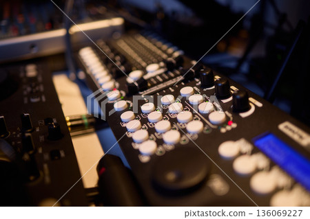 Engineer finetuning sound signals using patch cables, Focused technician adjusting levels on electronic patch cable setup with vivid colorful plugs and tactile interfaces 136069227
