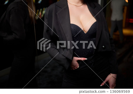 Fashionable lady in dark outfit exudes sophisticated aura, Sophisticated woman in sequined top and tailored blazer embodies fashionable confidence in lively nightlife environment Fashionable lady in dark outfit exudes sophisticated aura, Sophisticated woman in sequined top and tailored blazer embodies fashionable confidence in lively nightlife environment 136069569