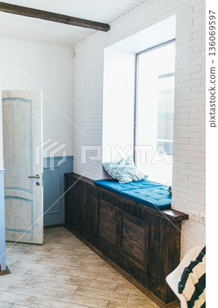 Sunny retreat filled with plush cushions. Comfortable corner bathed in sunlight and soft pillows. Charming cozy hideaway with sunbeams and plush cushions for relaxation 136069597