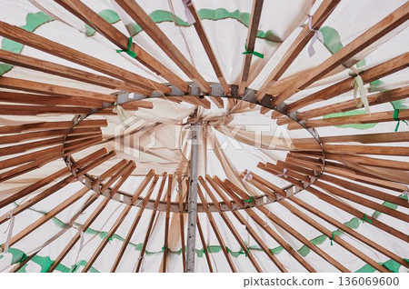 Decorative umbrella with intricate craftsmanship. Vintage style paper parasol with wooden framework. Closeup of handcrafted parasol showcasing grain and joinery details 136069600
