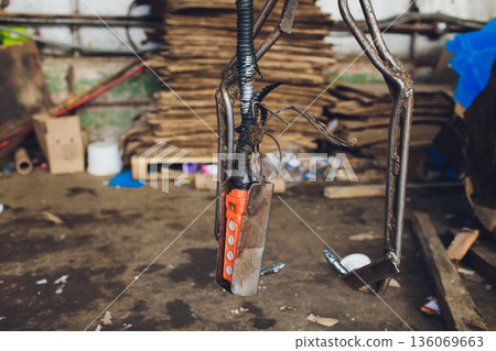 Restoration workshop with hanging tools, Vintage workshop filled with hanging cables and tools, Industrial repair environment with greased surfaces and vintage equipment 136069663