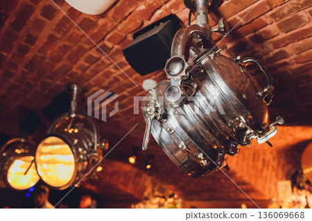 Cozy vintage ambiance, Intimate retro environment featuring soft amber illumination, Charming vintage decor highlighting warm lighting and elegant fixtures for events Cozy vintage ambiance, Intimate retro environment featuring soft amber illumination, Charming vintage decor highlighting warm lighting and elegant fixtures for events 136069668