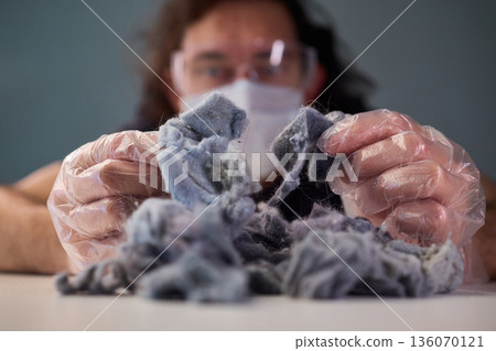 Detailed scene showing lint and cleaning, Warm indoor shot of hands clearing dryer lint, Closeup capturing hands inspecting fluffy lint fibers from machine filter Detailed scene showing lint and cleaning, Warm indoor shot of hands clearing dryer lint, Closeup capturing hands inspecting fluffy lint fibers from machine filter 136070121