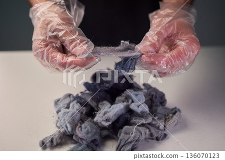Detailed scene showing lint and cleaning, Warm indoor shot of hands clearing dryer lint, Closeup capturing hands inspecting fluffy lint fibers from machine filter Detailed scene showing lint and cleaning, Warm indoor shot of hands clearing dryer lint, Closeup capturing hands inspecting fluffy lint fibers from machine filter 136070123