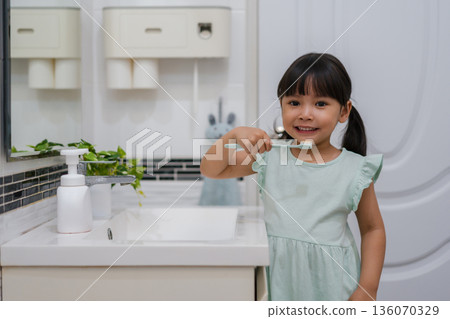 girl child brushing teeth in bathroom girl child brushing teeth in bathroom 136070329