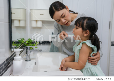 mother teaching girl child to brushing teeth in bathroom mother teaching girl child to brushing teeth in bathroom 136070333