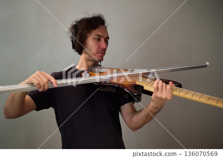 Powerful bass performance, Dynamic performer passionately communicating through bass guitar, Musician with curly hair immersed in expressive bass playing in studio environment Powerful bass performance, Dynamic performer passionately communicating through bass guitar, Musician with curly hair immersed in expressive bass playing in studio environment 136070569